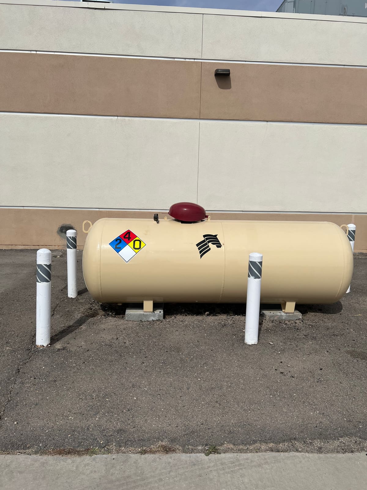 A propane tank installed at a commercial building, marked with an NFPA hazard placard, by Running Horse Services.